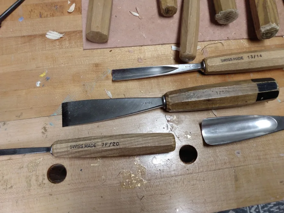Outils du sculpteur sur bois : ciseaux, gouges et ébauchoirs sur l'établi