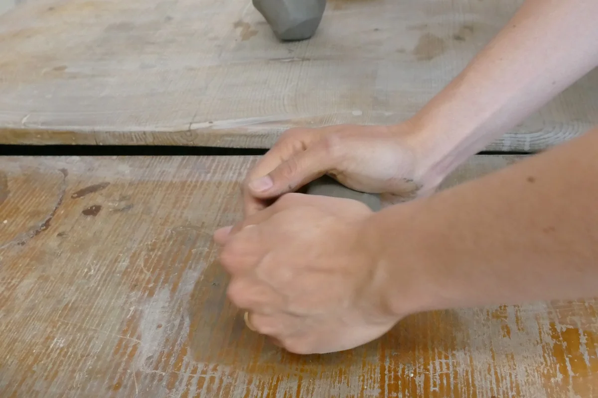 Sculpture en argile, étape 1 : pétrissage de la terre à la main pour chasser les bulles d'air