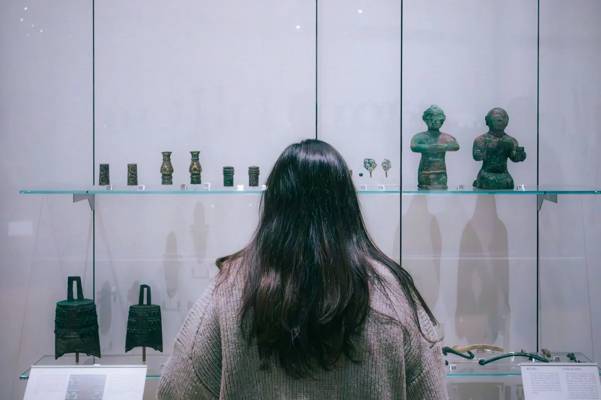 Visiteur admirant des sculptures anciennes dans un musée